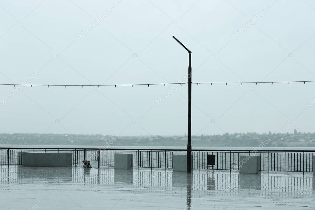Empty city embankment on grey rainy day