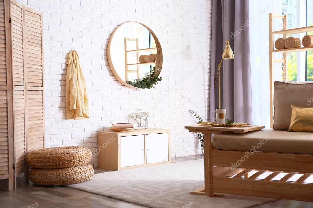 Elegant room interior with round mirror on brick wall