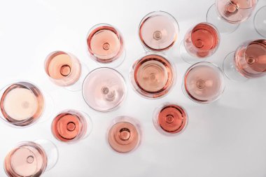 Beyaz arka planda gül şarabı ile farklı bardaklar, üst görünümü