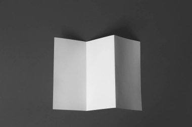 Koyu gri arka plan üzerine boş broşür, üst görünüm. Tasarım için alay