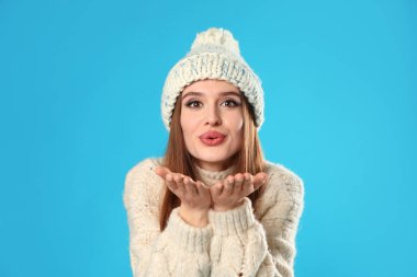 Mavi arka planda Noel süveteri giyen genç kadın