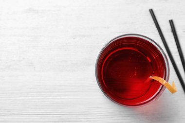 Beyaz ahşap arka plan üzerinde portakal kabuğu ile lezzetli ferahlatıcı kokteyl Cam, üst görünümü. Metin için alan