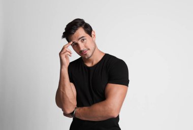 Gri arka plan üzerinde siyah t-shirt yakışıklı genç adam Portresi
