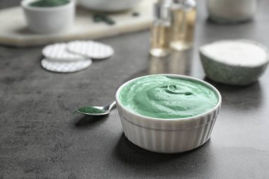 Gri masa üzerinde spirulina yüz maskesi Kase