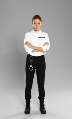 Gri arka planda üniformalı kadın güvenlik görevlisi