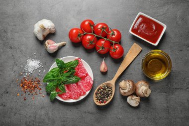 Gri masada pizza için taze malzemelerle düz yatıyordu kompozisyon