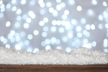 Bulanık arka plana karşı ahşap yüzeyde kar yığını. Noel sezonu