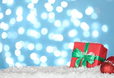Mavi arka plan karşı kar üzerinde Noel dekorasyon ve hediye kutusu