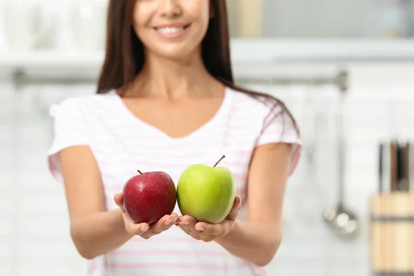 Mujer sosteniendo manzanas frescas en la cocina, primer plano — Foto de Stock