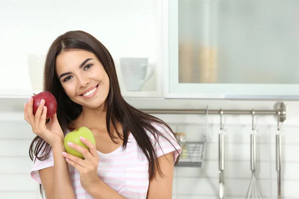 Mujer feliz sosteniendo manzanas frescas en la cocina. Espacio para texto — Foto de Stock