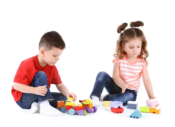 Milé malé děti si hrají s hračkama na bílém pozadí — Stock fotografie