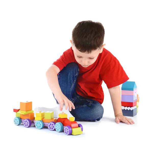 Милий маленький хлопчик грає з іграшками на білому тлі — стокове фото