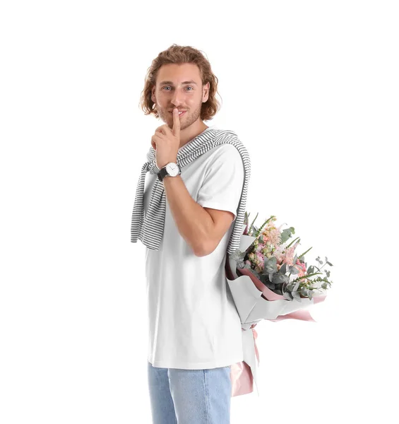 Jovem homem bonito escondendo lindo buquê de flores atrás de suas costas no fundo branco — Fotografia de Stock