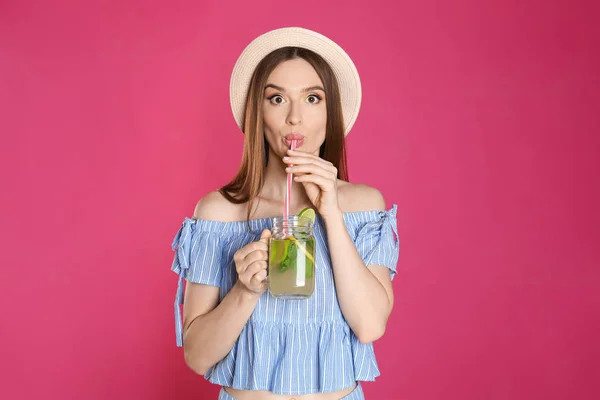 Emocjonalna młoda kobieta picie naturalnej detox lemoniady na różowym tle — Zdjęcie stockowe