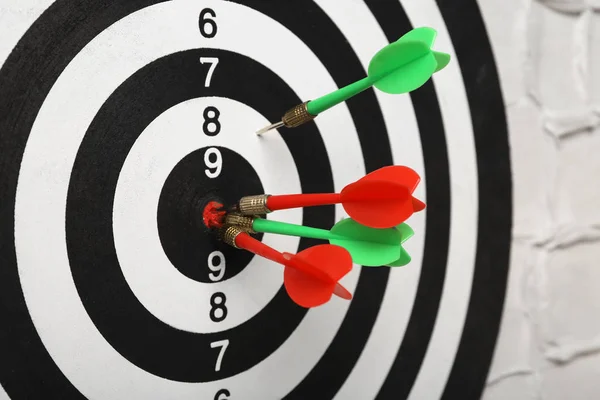 Arrows hitting dart board on white textured wall, closeup — Stock Photo, Image