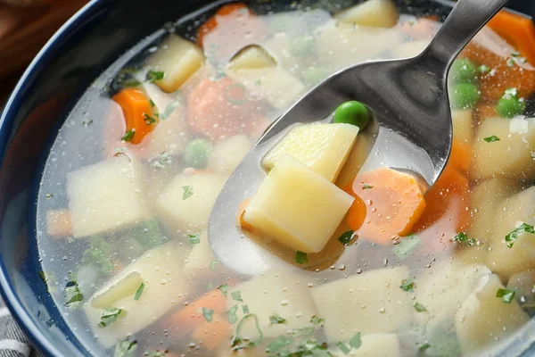 Colher de sopa de legumes caseira fresca sobre tigela cheia, close-up — Fotografia de Stock