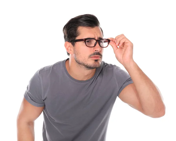 Young man with vision problem wearing glasses on white background — Stock Photo, Image