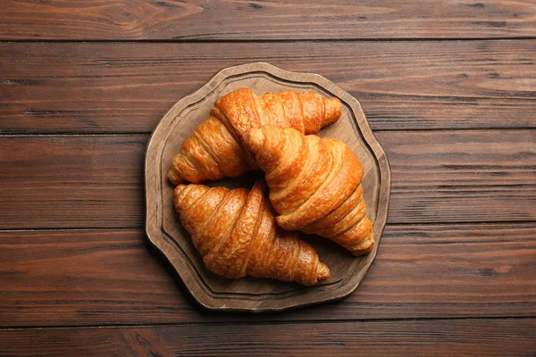 Tafel mit leckeren Croissants auf Holzgrund, Draufsicht. französisches Gebäck — Stockfoto