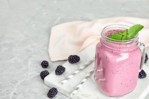 Delicioso batido de mora en tarro de albañil sobre mesa de mármol — Foto de Stock