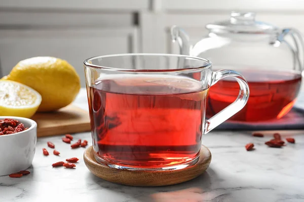 Gesunder Goji-Tee mit Zitrone in Glasschale auf Marmortisch — Stockfoto