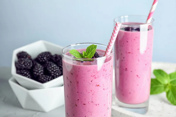 Delicioso batido de mora en vasos sobre mesa ligera —  Fotos de Stock