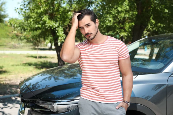 Çekici genç adam yakın lüks araba açık havada