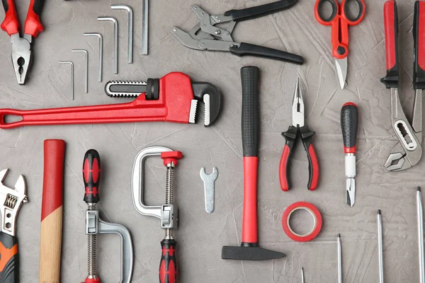 Gri taş masa üzerinde onarım araçları ile düz döşeme kompozisyonu