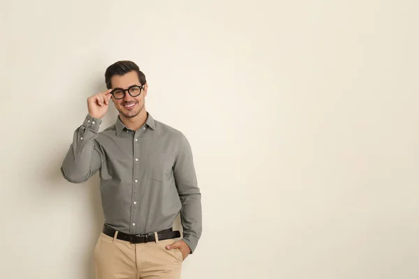 Joven con gafas sobre fondo beige. Espacio para texto —  Fotos de Stock