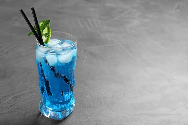 Glas leckerer erfrischender Cocktail mit Minze und Limette auf grauem Tisch. Raum für Text — Stockfoto