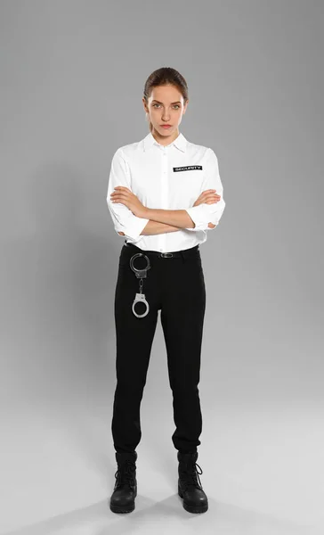 Kvinnlig säkerhetsvakt i uniform på grå bakgrund — Stockfoto