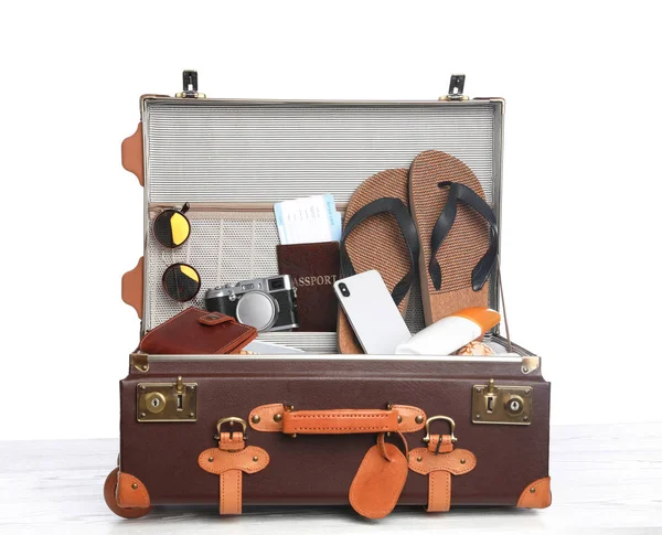 Beyaz arka planda farklı plaj nesneleri ile açık vintage bavul