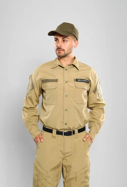 Masculino segurança guarda no uniforme no cinza fundo — Fotografia de Stock