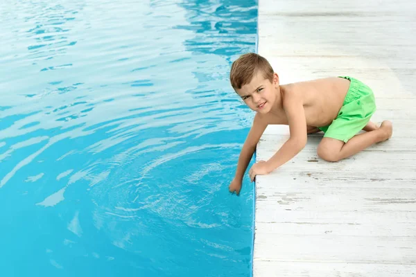 Niño pequeño cerca de la piscina al aire libre. Situación peligrosa — Foto de Stock