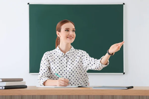 Portret van de jonge vrouwelijke leraar in de klas — Stockfoto