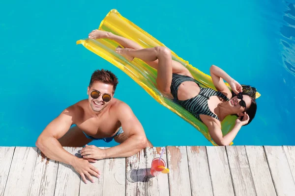 Happy young couple in outdoor swimming pool, above view — Stock Photo, Image