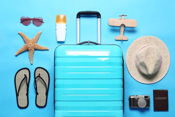 Composición plana con maleta y objetos de playa sobre fondo azul — Foto de Stock