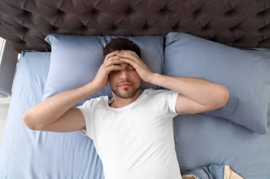 Yastığın üzerinde yatan uykulu adam, yukarıdan bakın. Yat -madan