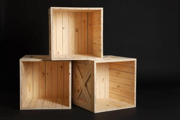 Grupo de caixas de madeira em fundo preto — Fotografia de Stock