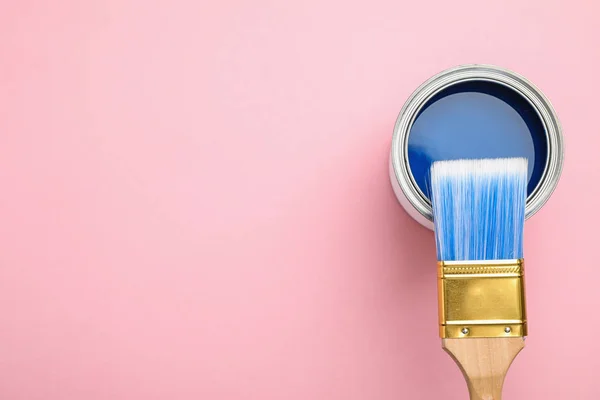 Lata abierta con pintura azul y pincel sobre fondo rosa, vista superior. Espacio para texto — Foto de Stock