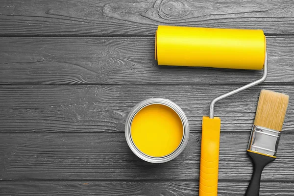 Flache Lagekomposition mit Farbdose, Pinsel und Rolle auf grauem Holzgrund. Raum für Text — Stockfoto