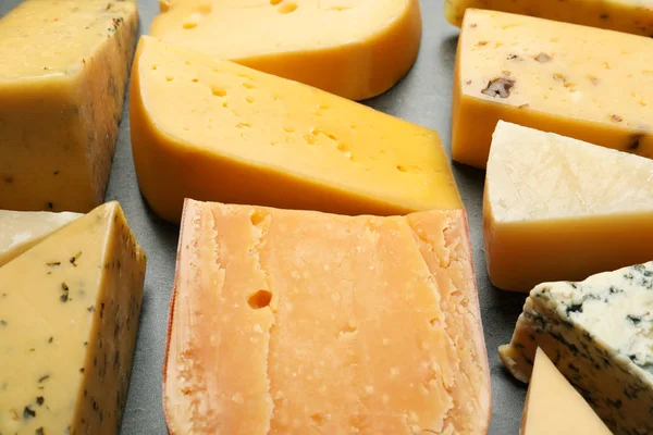 Diferentes tipos de queso delicioso sobre fondo de piedra, primer plano —  Fotos de Stock