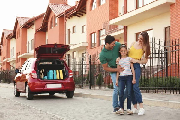 Boldog szülők ölelgetés lányuk közelében családi autó utcai — Stock Fotó