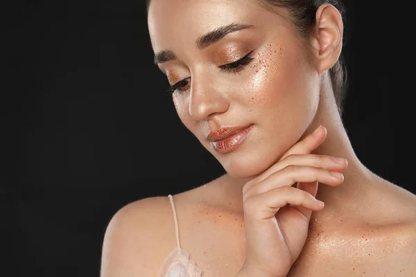 Mooie jonge vrouw met glitter make-up op zwarte achtergrond — Stockfoto