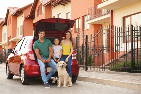 Famille heureuse avec chien près de la voiture dans la rue — Photo