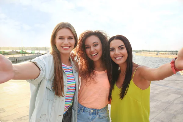 Happy young women taking selfie outdoors on sunny day — Stock Photo, Image