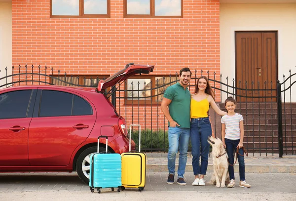 Familia feliz con su perro cerca de coche en la calle —  Fotos de Stock