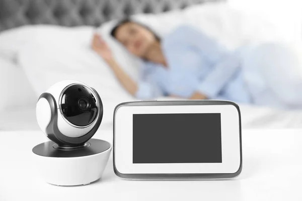 Babyfon und Kamera auf dem Tisch neben dem Bett mit Frau im Zimmer. Video-Kindermädchen — Stockfoto