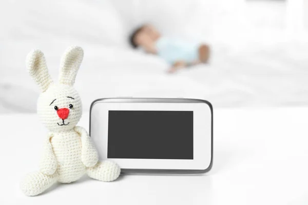Baby monitor and toy on table near bed with child in room. Video nanny — Stock Photo, Image