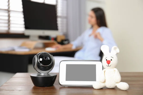 Babyfon, Kamera mit Spielzeug auf dem Tisch und Frau im Homeoffice. Video-Kindermädchen — Stockfoto