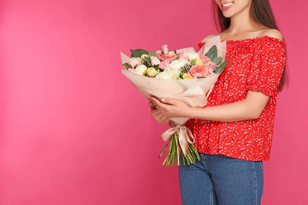 Ung kvinna som håller vackra blombukett på rosa bakgrund, närbild. Utrymme för text — Stockfoto